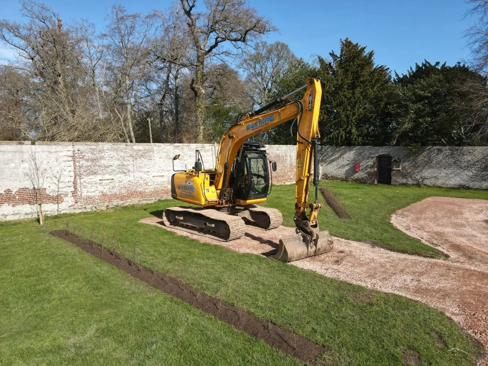 B&K Hume JCB excavator preparing paths and beds inside a walled garden